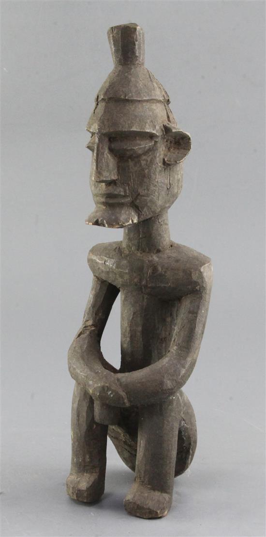 An African carved wood figure of a seated man, 35cm